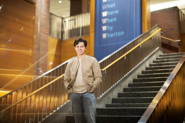 Derek Gibbs poses at the bottom of steps in Huntsman Hall.