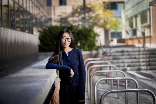 Jessica Mach standing outside with her arm resting on a low brick wall