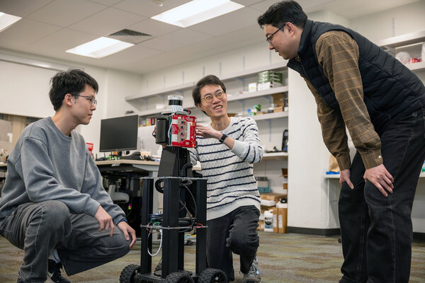 Zitong Lan, Haowen Lai and Mingmin Zhao with a robot in a lab.